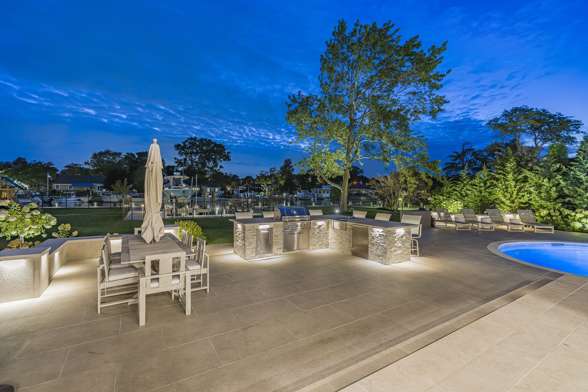 A finished outdoor kitchen and patio illuminated after dark.
